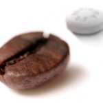 Grão de café com comprimido de Aspirina ao fundo