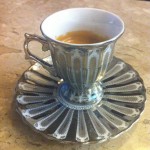 imagem de uma xícara de café de prata sobre uma mesa de marmore